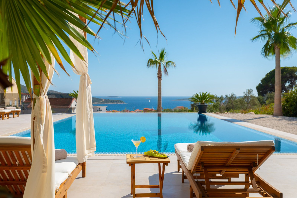 Infinity pool with palm trees, sun loungers and a sea view, Villa Golden Lion in Primo&scaron;ten
