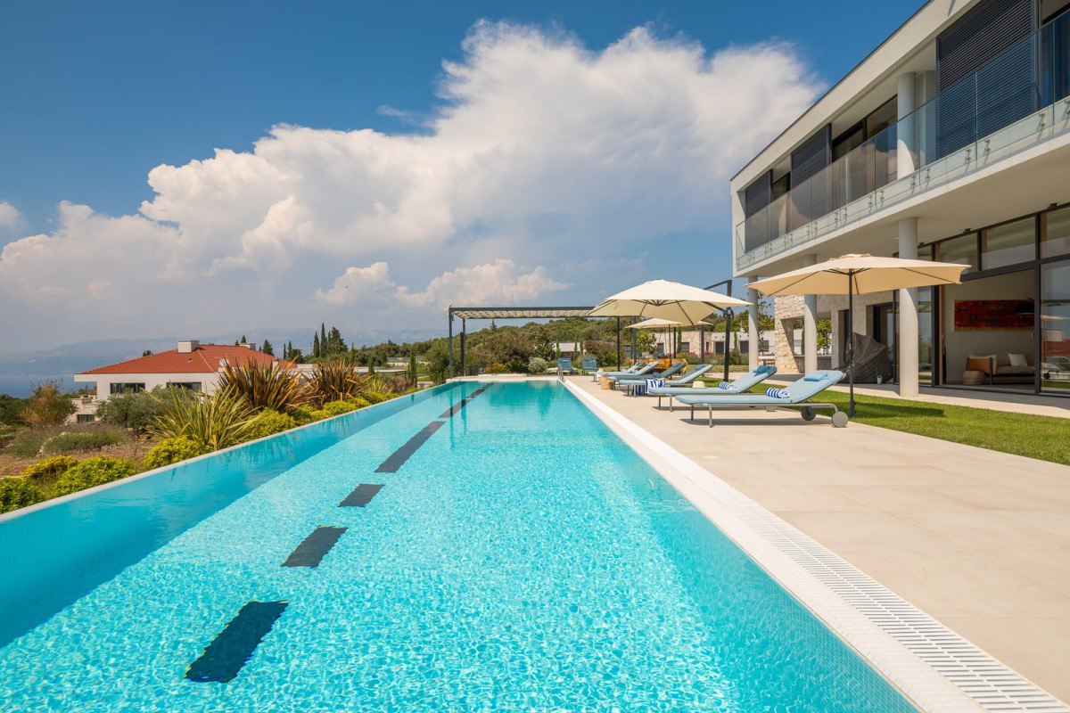 Long infinity pool with sun loungers beside a modern villa, Villa Johanna on the island of Brač