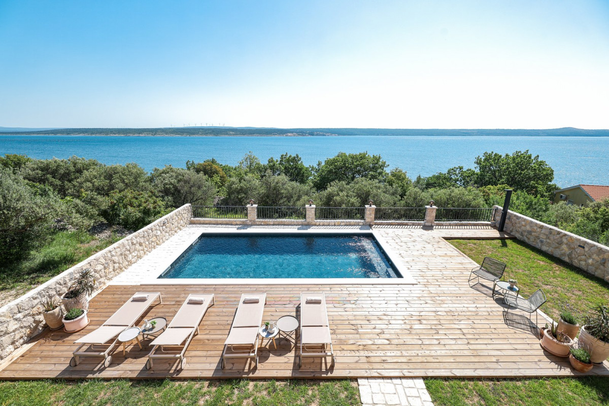 Pool on a wooden deck with sun loungers above the sea and olive trees, Villa Grota in Maslenica near Zadar